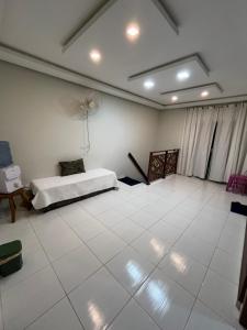 een slaapkamer met een bed en een tegelvloer bij Residência 02 in Japaratinga