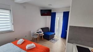 a bedroom with a bed and a table and a chair at Apartmani Toki Balkana in Mrkonjić Grad