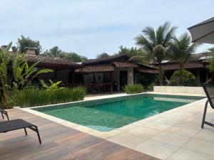een zwembad voor een huis bij Itamambuca Suites in Ubatuba