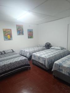 a room with three beds in a room at Hostal Y Hospedaje Familiar Amanecer del Valle 1 in Valledupar