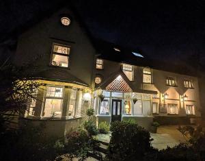 a large house at night with its lights on at Brigstock House in Llandudno