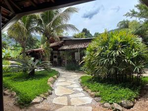 een huis met een loopbrug voor een tuin bij Itamambuca Suites in Ubatuba