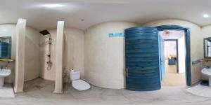 a bathroom with a blue shower and a toilet and a sink at Appartement La Plage Vue sur Mer pour les familles in Oualidia