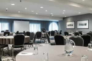 a conference room with tables and chairs and a screen at Hotel Manoir Victoria in Quebec City +34 photos