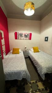 two beds in a room with red walls at Apartamento felicitat in Figueres
