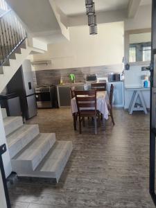a kitchen and dining room with a table and stairs at residence exotica in Île aux Chats