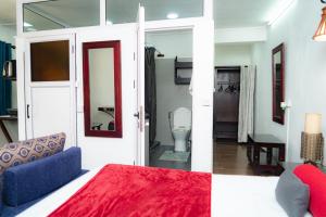 a room with a bed and a bathroom with a toilet at Ahavah Guesthouse in Trou dʼ Eau Douce +8 photos