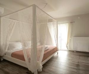 Villa Evanthia في Áyios Yeóryios: غرفة نوم بسرير مع مظلة