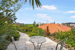 une terrasse avec une table et des chaises sur un trottoir dans l'établissement Private Coastal Sanctuary - 50m from Stunning Beach!, à Whakatane