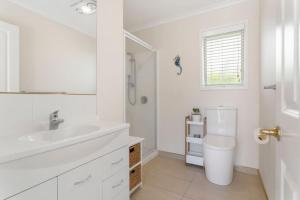 une salle de bain blanche avec un lavabo et des toilettes dans l'établissement Private Coastal Sanctuary - 50m from Stunning Beach!, à Whakatane