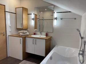 a bathroom with a sink and a tub and a mirror at Hanselerhof Jaufental Ratschings mit Sauna in Racines +35 photos