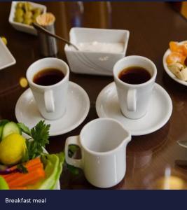 カイロにあるCairo Excellent Location hotelのテーブルの上のプレートにコーヒー2杯