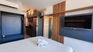 a bedroom with a bed and a flat screen tv at Acqua Beach Residence by CTA in Tamandaré +48 photos