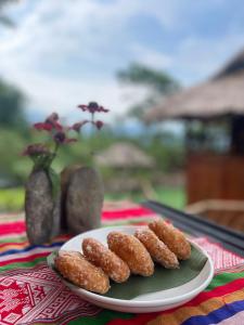 a plate with three fried donuts on a table at Mai Châu Medifarm Retreat in Mai Chau