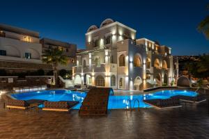a villa with a swimming pool at night at my life suites in Fira