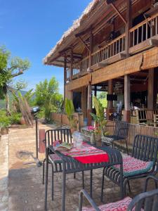 a table with a red table cloth on it in front of a building at Mai Châu Medifarm Retreat in Mai Chau
