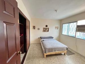 a small bedroom with a bed and a window at Casona el Sol in Veracruz