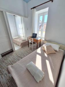 een slaapkamer met een bed en een bureau met een laptop bij balconi 1911 - Traditional house in Ydroussa, Samos in Ydroússa