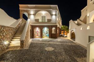 a villa with a staircase at night at my life suites in Fira