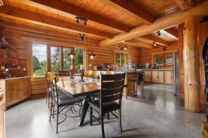 a kitchen with a dining room table and chairs at Hébergement "La Maison en Bois Rond" in Sainte-Marie