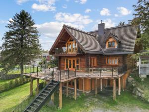 a log cabin with a deck and a house at Hébergement "La Maison en Bois Rond" in Sainte-Marie