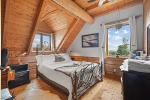 a bedroom with a bed and a wooden ceiling at Hébergement "La Maison en Bois Rond" in Sainte-Marie