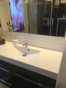 a bathroom with a white sink and a mirror at Townhouse with 4 bedrooms near Sørstrand  +26 photos