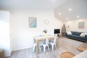 a living room with a table and chairs and a couch at Tranquil 3-Bed Home Pet-friendly Retreat with Community Pool in St Georges Basin