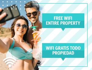 プンタ・カナにあるLOS CORALES Hotel Resort Villas & Apartments WIFI BEACH Club & SPAの浜辺のビキニ姿の女性写真を撮る男