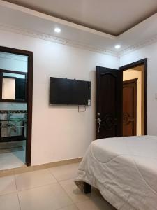 a bedroom with a bed and a flat screen tv on the wall at Habitación en la ciudad de Francisco de Orellana in Francisco de Orellana