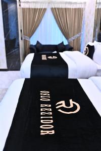 Una cama con una manta blanca y negra encima. en A2Z Boutique Hotel By Oslo, en Islamabad