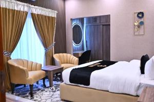 Una habitación de hotel con una cama y dos sillas. en A2Z Boutique Hotel By Oslo, en Islamabad