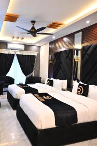 2 camas en una habitación de hotel con ventilador de techo en A2Z Boutique Hotel By Oslo, en Islamabad
