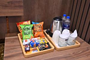 Dos bandejas de plástico con aperitivos y bebidas sobre una mesa en A2Z Boutique Hotel By Oslo, en Islamabad