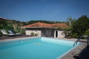 a large swimming pool in front of a house at WABI SABI-QuintAlão in Passô