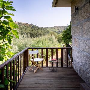 a wooden balcony with a chair and a view at WABI SABI-QuintAlão in Passô