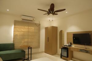 a living room with a couch and a ceiling fan at Hotel Amber Inn in Prayagraj