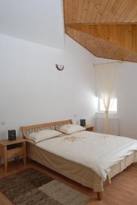 a bedroom with a large bed with a wooden ceiling at Vila Carpathia in Bran