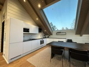 a kitchen with a table and a large window at Naava Chalet 402 Penthouse - Kattohuoneisto järvinäköalalla in Ähtäri