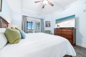 a bedroom with a white bed and a flat screen tv at The Oasis 2210 in Romar Beach +70 photos