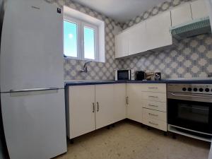 a kitchen with white cabinets and a window at El nido del mar in Almería