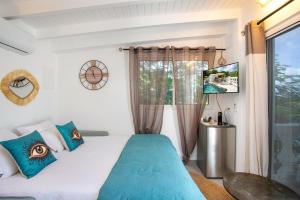 a bedroom with a bed with blue pillows and a window at Villa Princess sea view private pool Anse Marcel in Saint Martin +78 photos