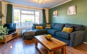 a living room with a blue couch and a table at Headingley Lodge - Suburban location with off street parking in Leeds