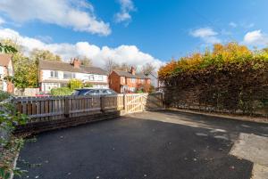 a car parked in a driveway next to a fence at Headingley Lodge - Suburban location with off street parking in Leeds