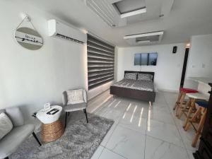 a bedroom with a bed and a couch and a table at Ocean Front 2 in San Juan