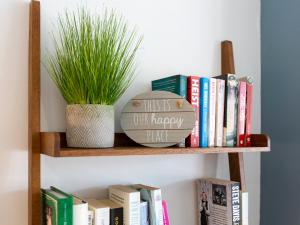 a book shelf with books and a plant on it at Anchorage View in Dartmouth