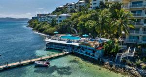 una casa sull'acqua con una barca in acqua di Point Pleasant Resort a Frydendal