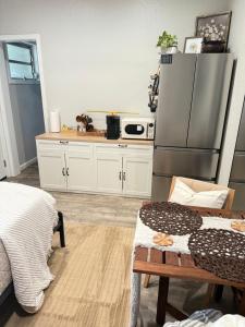 タラハシーにあるCozy Guest house near FSU Trails and the airportの白いキャビネットとステンレス製の冷蔵庫を備えたキッチン