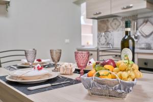 een tafel met een fruitmand en een fles wijn bij Cristina Tuscany Holiday in Poggibonsi