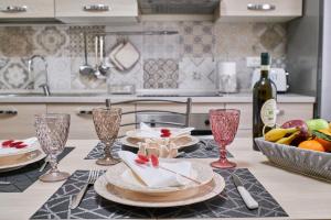 een keuken met een tafel met borden en wijnglazen bij Cristina Tuscany Holiday in Poggibonsi